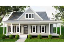 Charming home with a covered porch, black shutters, and well-manicured landscaping at 328 Green Pines Estates Dr, Kenly, NC 27542