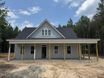 Charming one-story home with a covered front porch and light gray siding, nestled in a wooded lot at 328 Green Pines Estates Dr, Kenly, NC 27542