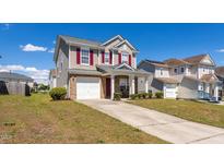 Charming two-story home featuring a front-facing garage, red shutters, and well-maintained landscaping at 3629 Brittlebank Dr, Raleigh, NC 27610