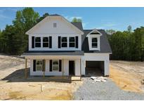 New two-story home featuring white siding, black windows, an attached garage and a covered front porch at 499 Beacon Hill Rd # 30, Lillington, NC 27546
