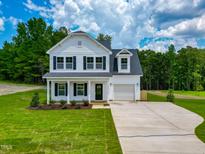 Charming two-story home featuring white siding, black shutters and a well manicured lawn at 499 Beacon Hill Rd # 30, Lillington, NC 27546