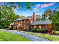 Elegant two-story brick home with manicured lawn and charming architectural details at 500 Old Greensboro Rd, Chapel Hill, NC 27516