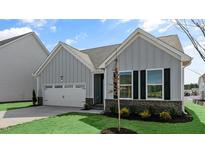 Charming home featuring vertical siding, black window shutters, a two-car garage, and well-maintained landscaping at 552 Lemon Daisy Ln, Knightdale, NC 27545