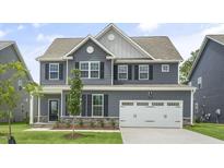 Charming two-story home with gray siding, black shutters, and a well-manicured front yard, perfect for curb appeal at 556 Lemon Daisy Ln, Knightdale, NC 27545