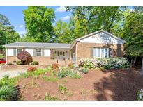 Charming brick home featuring manicured landscaping and a cozy front porch at 5713 Old Forge Cir, Raleigh, NC 27609