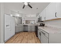 Well-lit kitchen featuring modern appliances, granite countertops, and wood-look flooring at 6120 Sunpointe Dr # 102, Raleigh, NC 27606