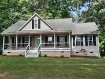 Charming single Gathering home boasting a cozy front porch, complemented by lush landscaping and mature trees at 640 Sagamore Dr, Louisburg, NC 27549