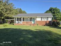 Charming single-story home featuring a brick foundation, light-colored siding, and a covered porch, perfect for relaxing at 66 Epsom Rocky Ford Rd, Henderson, NC 27537
