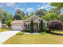 Charming single-story home featuring a manicured lawn and attached two-car garage at 71 Potted Plant Ct, Clayton, NC 27520