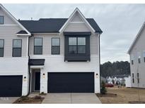 Charming two-story townhome features a painted brick facade, black garage door, and neutral siding accents at 1010 Westerland Way # 200, Durham, NC 27703