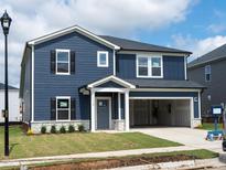 Two-story home with blue siding, white trim, stone accents, and an attached two-car garage at 1112 Landen Creek Ln, Zebulon, NC 27597
