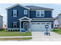 Two-story home featuring navy blue siding, a white two-car garage door, and manicured front lawn at 1112 Landen Creek Ln, Zebulon, NC 27597