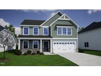 Charming two-story home with a two-car garage, complemented by a well-manicured lawn and decorative stone accents at 125 Cordoba Dr, Franklinton, NC 27525