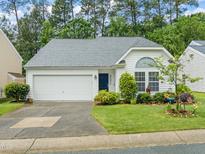 Charming one-story home with a manicured front lawn and attached two car garage at 1408 Fairmont St, Durham, NC 27713