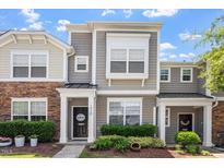 Charming townhome with stone and siding, featuring a welcoming front porch and manicured landscaping at 1710 Grace Point Rd, Morrisville, NC 27560