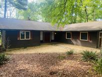 Charming single-story home with a brown exterior and meticulously maintained landscaping in a lovely wooded setting at 1812 Crepe Myrtle Dr, Sanford, NC 27330