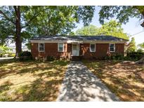 Charming brick home with a well-maintained lawn and a concrete walkway leading to the front door at 210 S Hughes St, Apex, NC 27502