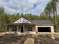 New construction single story home featuring an attached garage and a covered front porch at 214 Green Pines Estates Dr, Kenly, NC 27542