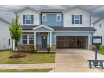Charming two-story home with an attached two-car garage, landscaped yard, and a partially brick facade at 2226 Cherry Creek Rd, Haw River, NC 27258