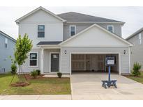 Two-story home with light gray siding, open garage, and a manicured front lawn with young tree at 2230 Cherry Creek Rd, Haw River, NC 27258