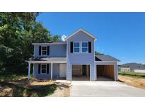 Charming two-story home boasts a covered front porch and an attached two-car garage, perfect for any Gathering at 2554 Whitetail Rd, Nashville, NC 27856
