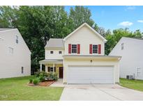 Charming two-story home featuring a 2-car garage and a landscaped front yard at 3223 Polite Ln, Raleigh, NC 27610
