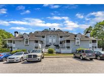 Exterior view of a multi-story apartment building with parking lot, balconies, and well maintained landscaping at 4907 Hollenden Dr # 106, Raleigh, NC 27616