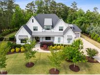 Stunning two-story home with professional landscaping, gray roof, and a welcoming covered front porch at 5125 Avalaire Oaks Dr, Raleigh, NC 27614