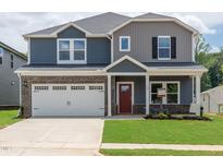 Charming two-story home featuring a brick and vinyl exterior, a two-car garage, and a well-manicured lawn at 729 Deschutes Dr, Garner, NC 27529