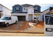 New home under construction with blue and gray siding, a two-car garage, and a covered front porch at 745 Deschutes Dr, Garner, NC 27529