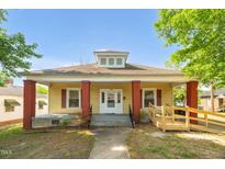 Charming single-story home featuring a welcoming front porch, vibrant red columns, and a convenient wheelchair ramp at 1007 Grace Ave, Burlington, NC 27217