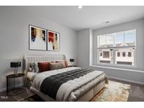 Bright bedroom with a cozy bed, stylish decorations, and a large window with blinds at 1018 Westerland Way # 204, Durham, NC 27703