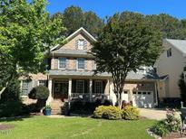 Charming two-story brick home featuring a well-manicured lawn and inviting front porch at 1021 Golden Star Way, Wake Forest, NC 27587