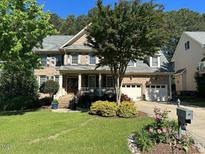 Inviting brick two-story home with a landscaped front yard and a cozy porch area at 1021 Golden Star Way, Wake Forest, NC 27587