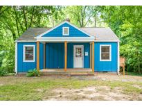 Charming blue cottage featuring a cozy front porch and inviting curb appeal at 1402 Robinhood Rd, Durham, NC 27701