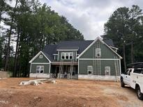 New construction showing a two-story home with green siding and a black roof, featuring ladders for ongoing work at 194 Landon Ridge, Sanford, NC 27330
