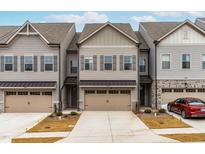 Charming townhome exterior with a two-car garage and beautifully landscaped front yard at 2140 Stegemann St, Apex, NC 27502