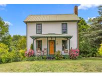 Charming two-story home with a quaint front porch, rocking chairs, porch swing and beautiful landscaping at 2440 Glencoe St, Burlington, NC 27217