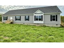 Charming single-story home features gray siding, black shutters, and a well-maintained green lawn at 2912 Epps Clark Rd, Siler City, NC 27344