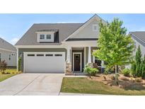 Charming home featuring a two-car garage, welcoming front porch, and manicured lawn at 345 Warm Wind Dr, Clayton, NC 27527
