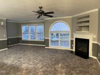 Spacious living room with modern fireplace, large windows, and stylish ceiling fan at 3489 Forestdale Dr # 2D, Burlington, NC 27215