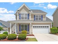 Charming two-story home with blue shutters, manicured landscaping, and an attached two-car garage at 4509 Joe Cotton Dr, Knightdale, NC 27545