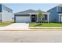 Charming single-story home with a well-manicured lawn and attached two car garage at 648 White Birch Ln, Angier, NC 27501