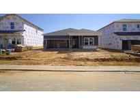 New home construction with a blue facade, featuring an open garage and a partially landscaped yard at 648 White Birch Ln, Angier, NC 27501