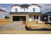 New construction home featuring brick facade and an attached garage ready for customization and personalization at 658 White Birch Ln, Angier, NC 27501