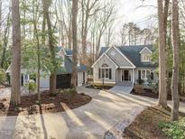 Charming grey house with a two-car garage, surrounded by mature trees and a long driveway at 7116 Asheway Dr, Holly Springs, NC 27540