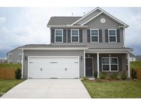 Charming two-story home featuring a two-car garage, neutral siding, and well-manicured front lawn at 1043 Thicket Dr # 358, Burlington, NC 27217