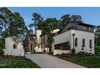Stunning two-story home featuring a painted brick exterior, dark trim, manicured lawn and driveway at 1222 Duplin Rd, Raleigh, NC 27607
