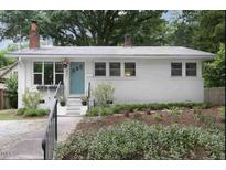 Charming single-story home featuring light-colored exterior, landscaped front yard, and inviting blue door at 1521 N Duke St, Durham, NC 27701