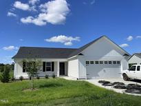 Beautiful, new construction, single story home with white siding, dark roof, and two car garage at 199 Lotus Ave, Smithfield, NC 27577